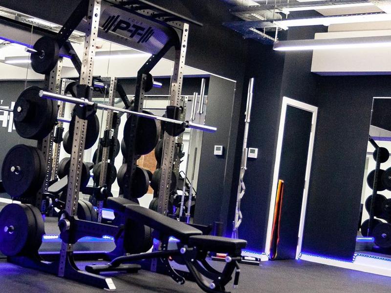 Close view of a power rack with the studio's branded pull-up bar